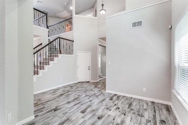 7711 Heather Ridge Ct, Irving, TX 75063 - unfurnished living room featuring a towering ceiling, wood finished floors, stairway, and baseboards