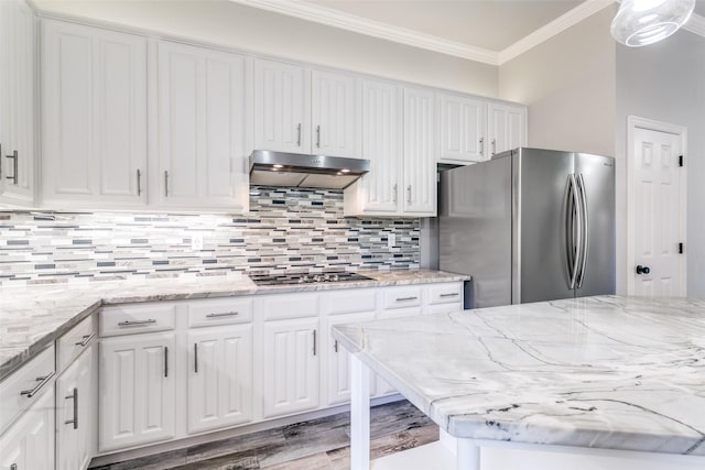 7711 Heather Ridge Ct, Irving, TX 75063 - kitchen with freestanding refrigerator, under cabinet range hood, black electric stovetop, white cabinets, and crown molding