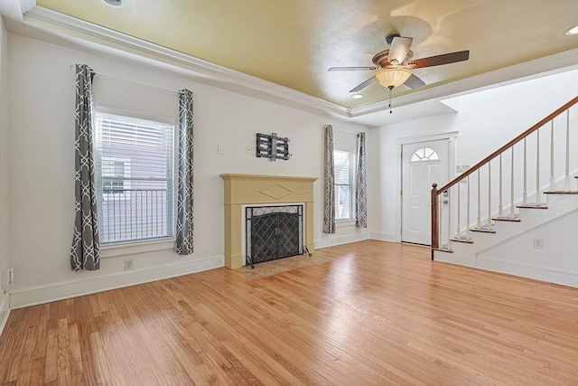 4532 Calmont Ave, Fort Worth, TX 76107 - unfurnished living room featuring a tray ceiling, wood finished floors, stairway, a ceiling fan, and baseboards