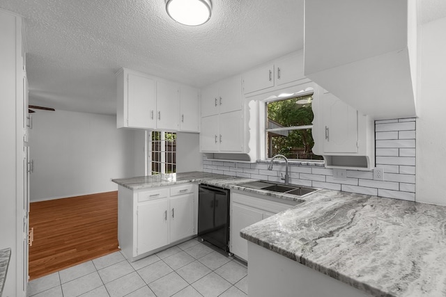 6032 Highcrest Dr, Watauga, TX 76148 - kitchen featuring a sink, black dishwasher, a peninsula, a textured ceiling, and white cabinetry