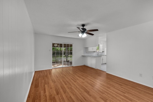 6032 Highcrest Dr, Watauga, TX 76148 - unfurnished living room featuring light wood-type flooring, ceiling fan, and baseboards