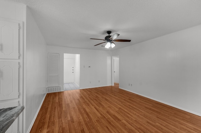 6032 Highcrest Dr, Watauga, TX 76148 - empty room featuring wood finished floors, a ceiling fan, a textured ceiling, and baseboards