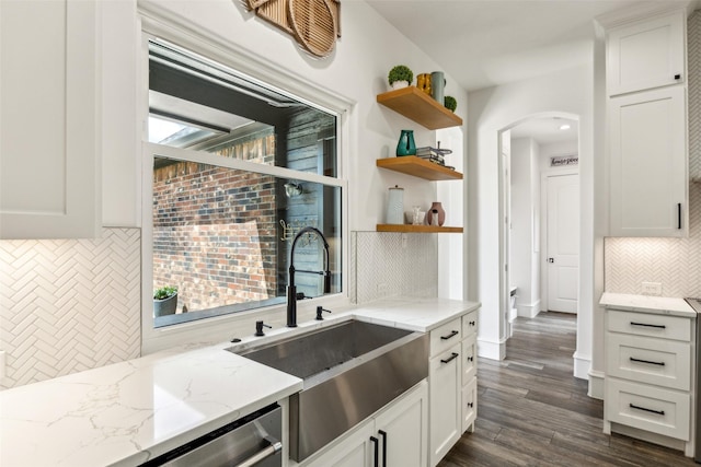 5900 Stage Coach Cir, Westlake, TX 76262 - kitchen featuring open shelves, a sink, decorative backsplash, arched walkways, and white cabinetry