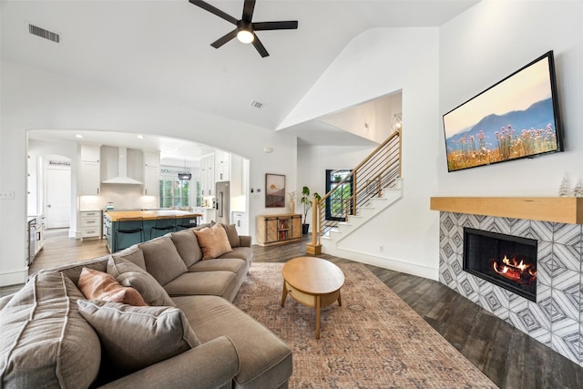 5900 Stage Coach Cir, Westlake, TX 76262 - living room with ceiling fan, wood finished floors, a fireplace, high vaulted ceiling, and arched walkways