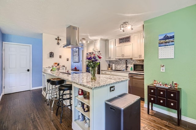 5225 Marks Cir, The Colony, TX 75056 - kitchen featuring island exhaust hood, stainless steel appliances, a kitchen bar, and dark wood-style floors