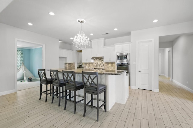 7401 Sabine Dr, Mckinney, TX 75071 - kitchen with stainless steel appliances, backsplash, a chandelier, baseboards, and white cabinetry