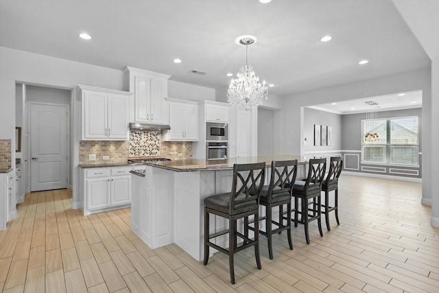 7401 Sabine Dr, Mckinney, TX 75071 - kitchen with appliances with stainless steel finishes, a chandelier, white cabinetry, tasteful backsplash, and recessed lighting