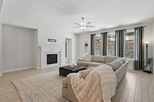 7401 Sabine Dr, Mckinney, TX 75071 - living room with a ceiling fan, baseboards, light wood-type flooring, and a glass covered fireplace