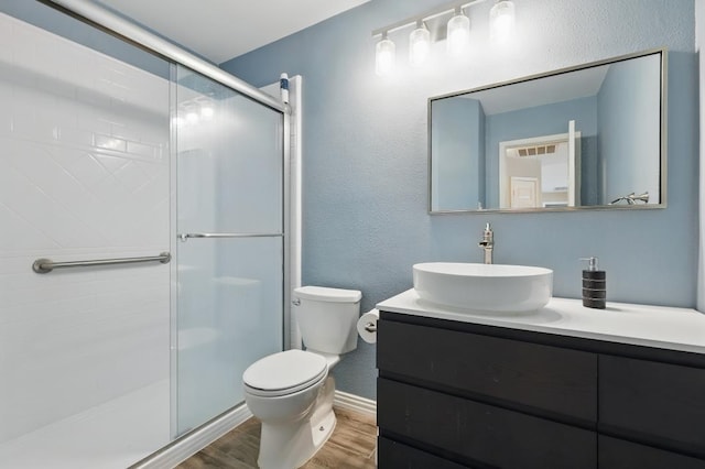1925 Kiestwood Cir, Plano, TX 75025 - full bath with wood finished floors, a stall shower, toilet, vanity, and a textured wall