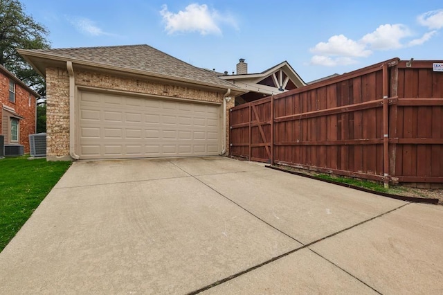 1925 Kiestwood Cir, Plano, TX 75025 - garage featuring fence, concrete driveway, and central AC