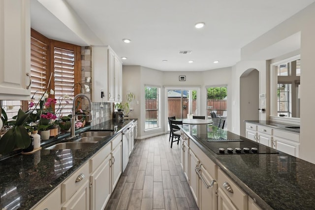 1925 Kiestwood Cir, Plano, TX 75025 - kitchen with a sink, black electric stovetop, wood finished floors, dark stone countertops, and recessed lighting