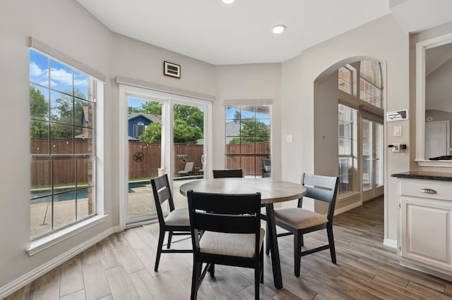 1925 Kiestwood Cir, Plano, TX 75025 - dining room featuring arched walkways, light wood-type flooring, recessed lighting, and baseboards