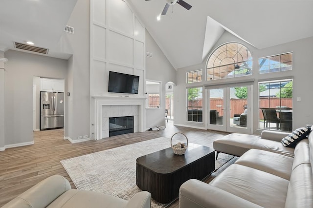 1925 Kiestwood Cir, Plano, TX 75025 - living room featuring high vaulted ceiling, ceiling fan, light wood finished floors, baseboards, and a fireplace