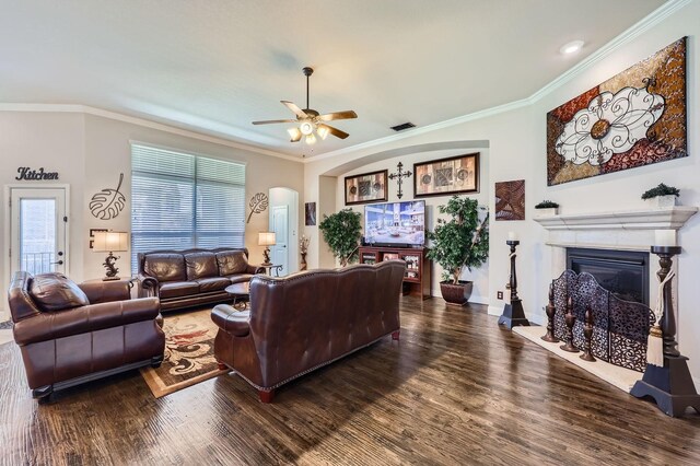 600 Oakmont Ct, Desoto, TX 75115 - living room with a fireplace with raised hearth, ceiling fan, wood finished floors, crown molding, and arched walkways