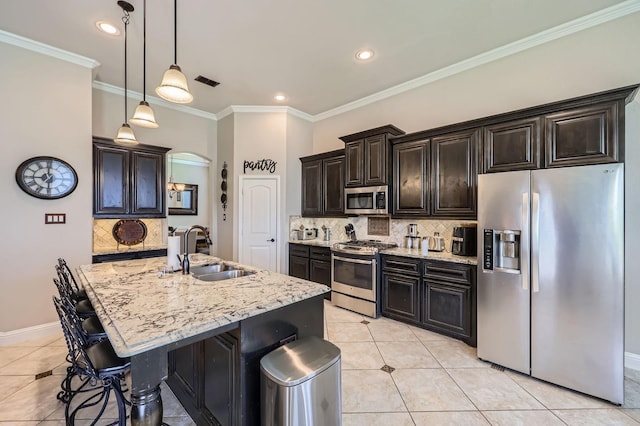 600 Oakmont Ct, Desoto, TX 75115 - kitchen featuring stainless steel appliances, a sink, light tile patterned floors, arched walkways, and crown molding
