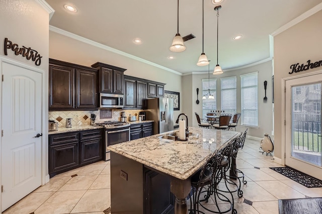 600 Oakmont Ct, Desoto, TX 75115 - kitchen with stainless steel appliances, a sink, light tile patterned floors, a breakfast bar, and ornamental molding