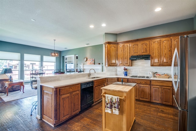 519 Butternut Dr, Garland, TX 75044 - kitchen with freestanding refrigerator, black dishwasher, a sink, under cabinet range hood, and butcher block counters