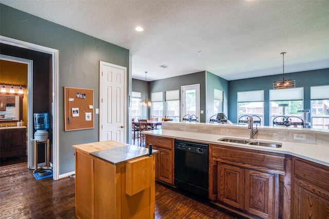519 Butternut Dr, Garland, TX 75044 - kitchen featuring black dishwasher, a sink, a textured ceiling, brown cabinets, and dark wood-style floors