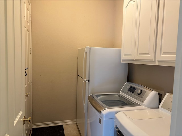 519 Butternut Dr, Garland, TX 75044 - clothes washing area with washing machine and dryer, baseboards, cabinet space, and tile patterned flooring