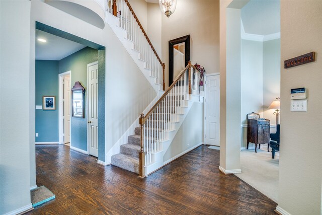 519 Butternut Dr, Garland, TX 75044 - stairs featuring wood finished floors, baseboards, and a towering ceiling