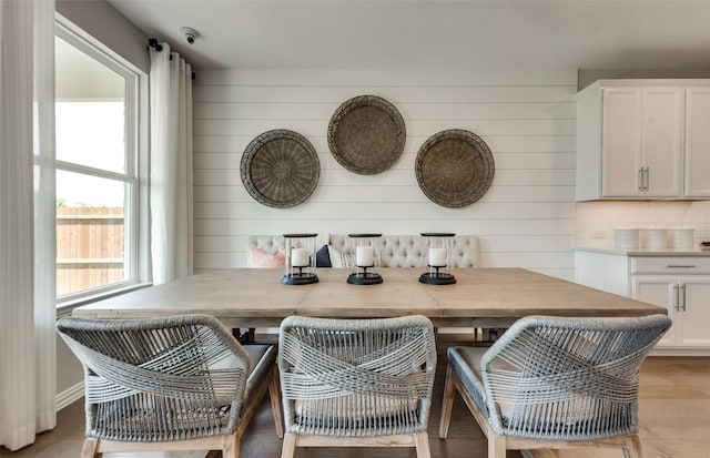 dining area featuring wood walls and light wood-style floors