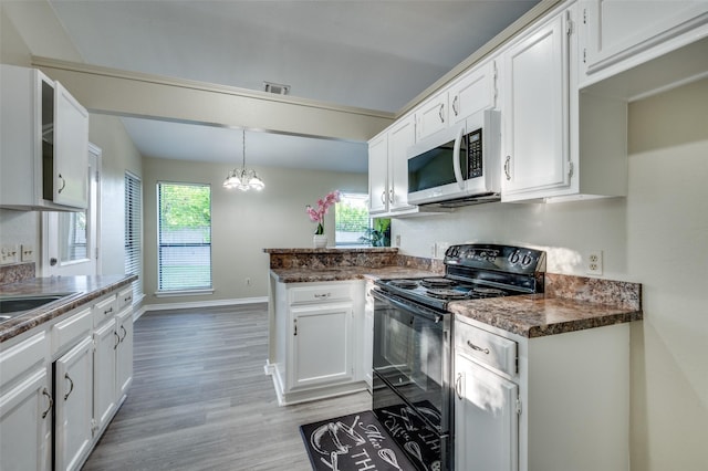 2702 Glen Ridge Dr, Arlington, TX 76016 - kitchen featuring white microwave, electric range, a peninsula, and white cabinets