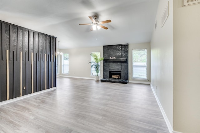 2702 Glen Ridge Dr, Arlington, TX 76016 - unfurnished living room featuring a ceiling fan, wood finished floors, a brick fireplace, baseboards, and vaulted ceiling