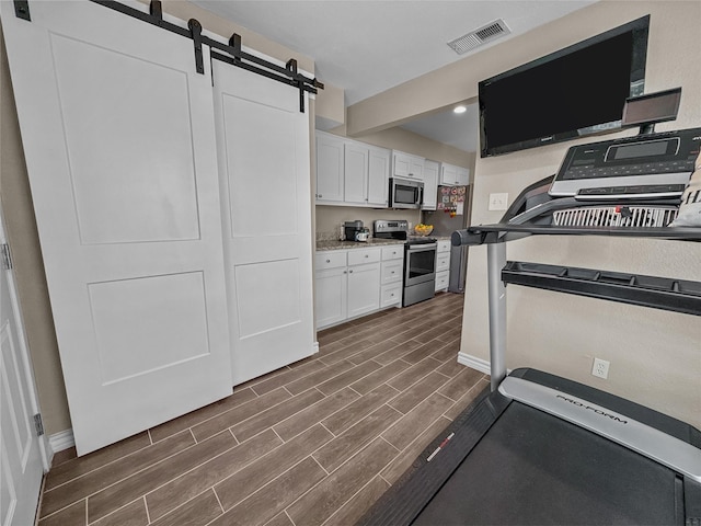 2114 Cottage Oak Ln, Colleyville, TX 76034 - workout area featuring wood finish floors, baseboards, a barn door, and recessed lighting