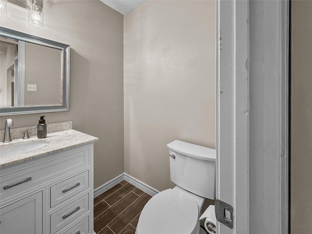 2114 Cottage Oak Ln, Colleyville, TX 76034 - bathroom with baseboards, wood finish floors, vanity, and toilet