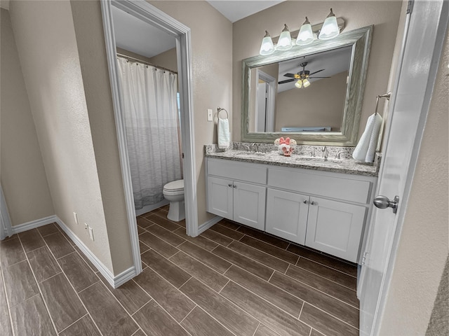 2114 Cottage Oak Ln, Colleyville, TX 76034 - bathroom featuring wood tiled floors, ceiling fan, double vanity, toilet, and baseboards
