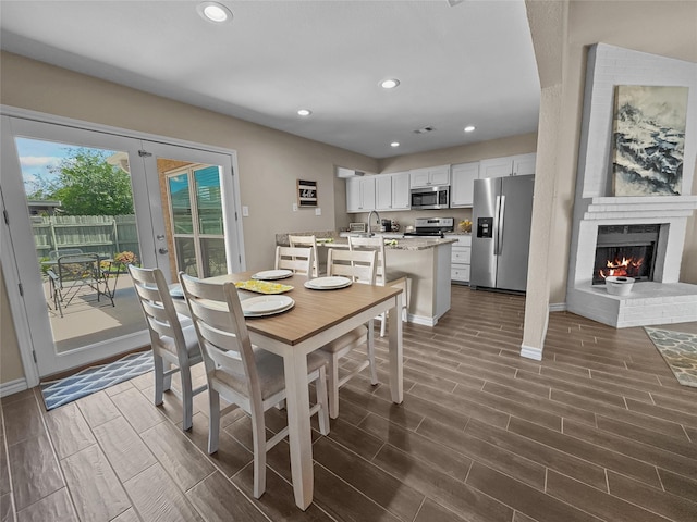 2114 Cottage Oak Ln, Colleyville, TX 76034 - dining area featuring wood finish floors, recessed lighting, baseboards, a brick fireplace, and french doors