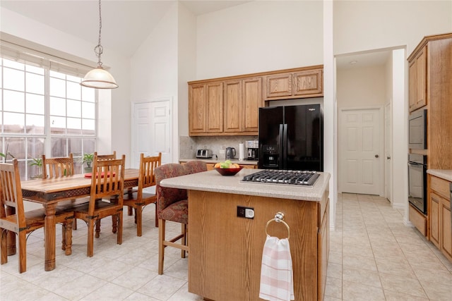 4301 Sandra Lynn Dr, Flower Mound, TX 75022 - kitchen featuring black appliances, high vaulted ceiling, tasteful backsplash, a kitchen island, and pendant lighting