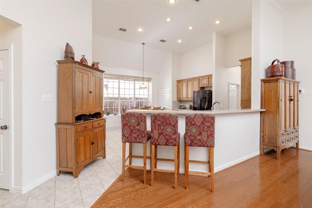 4301 Sandra Lynn Dr, Flower Mound, TX 75022 - kitchen featuring black fridge with ice dispenser, recessed lighting, baseboards, a high ceiling, and a peninsula