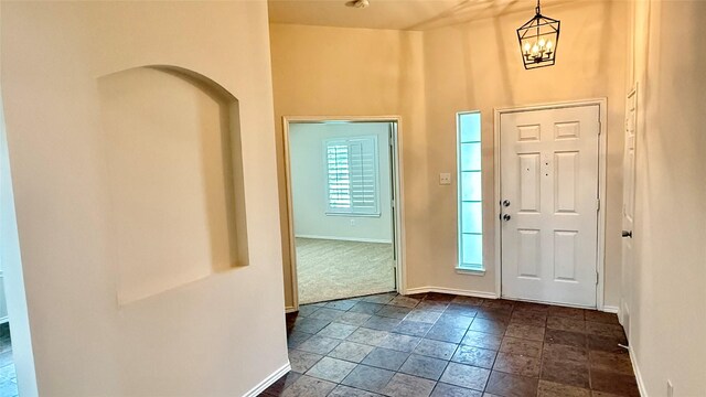 1924 Cliffrose Dr, Little Elm, TX 75068 - entryway with baseboards, a chandelier, a towering ceiling, and dark stone finish flooring