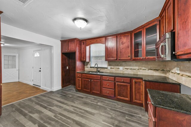 3617 Gene Ln, Haltom City, TX 76117 - kitchen featuring stainless steel microwave, a sink, dark brown cabinets, backsplash, and dark wood finished floors
