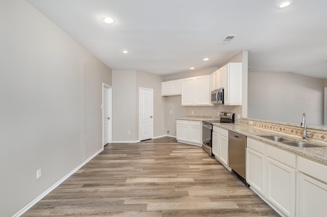 2109 Northridge Dr, Forney, TX 75126 - kitchen featuring stainless steel appliances, a sink, recessed lighting, tasteful backsplash, and light wood-style flooring