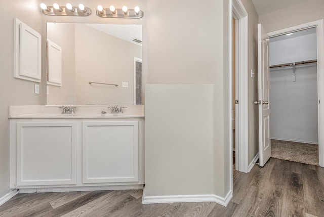 2109 Northridge Dr, Forney, TX 75126 - full bathroom with wood finished floors, a walk in closet, double vanity, and baseboards