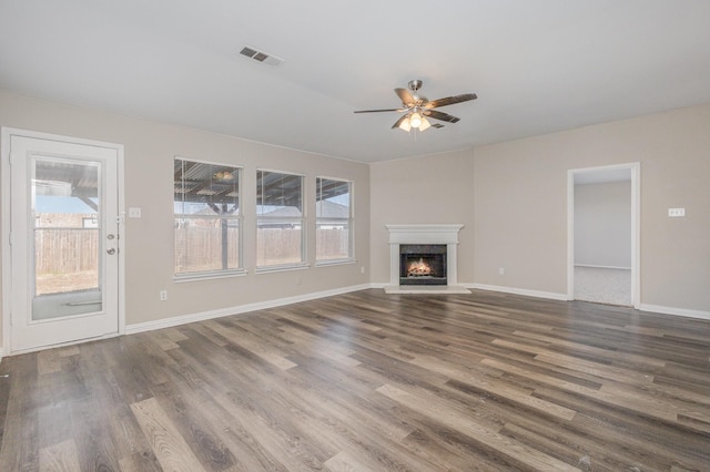 2109 Northridge Dr, Forney, TX 75126 - unfurnished living room featuring ceiling fan, wood finished floors, a warm lit fireplace, and baseboards