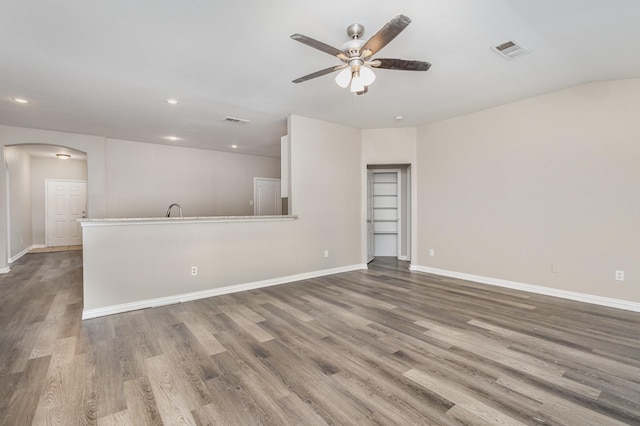 2109 Northridge Dr, Forney, TX 75126 - unfurnished living room featuring a ceiling fan, arched walkways, recessed lighting, wood finished floors, and baseboards