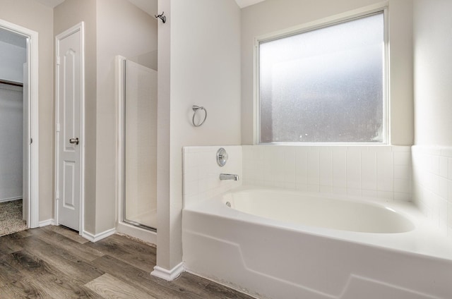 2109 Northridge Dr, Forney, TX 75126 - bathroom with wood finished floors, a stall shower, a bath, and baseboards