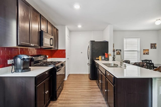 5645 Mcclelland St, Forney, TX 75126 - kitchen featuring black appliances, a sink, light wood finished floors, light countertops, and recessed lighting