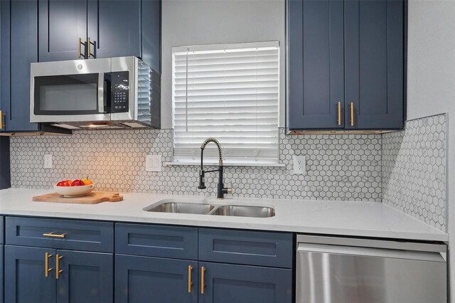 6005 Redwood Ln, Rowlett, TX 75089 - kitchen featuring appliances with stainless steel finishes, blue cabinetry, a sink, light countertops, and backsplash