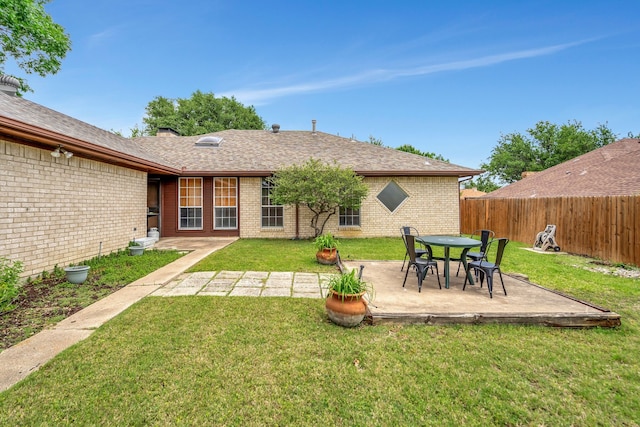 rear view of house with brick siding, a patio, and roof with shingles