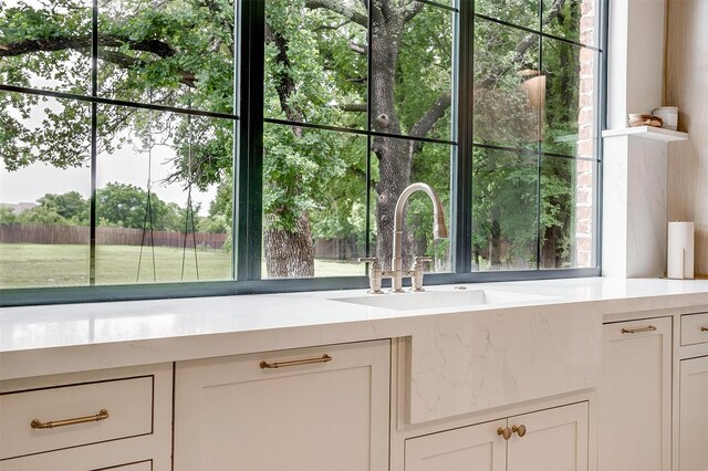 7758 Barber Ranch Rd, Fort Worth, TX 76126 - kitchen view of white cabinetry, a sink, and light stone countertops