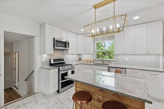 810 Turner Blvd, Grand Prairie, TX 75050 - kitchen featuring stainless steel appliances, a sink, light marble finish flooring, a kitchen breakfast bar, and decorative backsplash