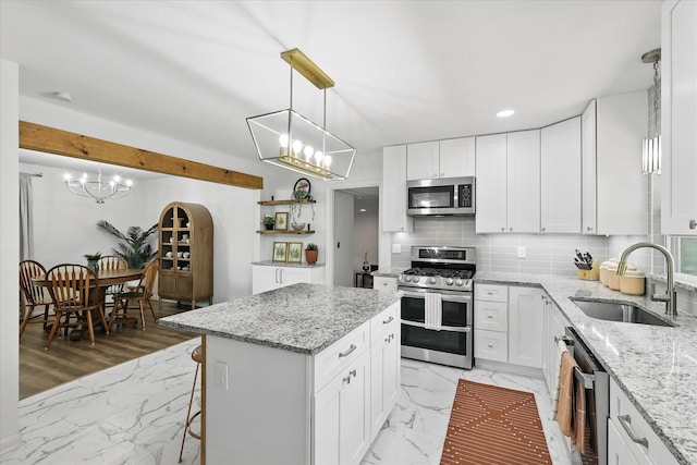 810 Turner Blvd, Grand Prairie, TX 75050 - kitchen with appliances with stainless steel finishes, a sink, a chandelier, a center island, and backsplash