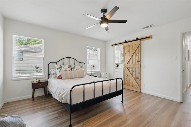 810 Turner Blvd, Grand Prairie, TX 75050 - bedroom featuring a barn door, light wood-style floors, baseboards, and a ceiling fan