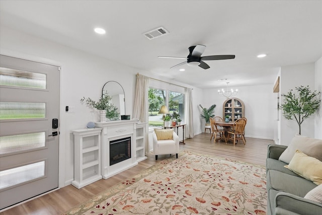 810 Turner Blvd, Grand Prairie, TX 75050 - living room featuring light wood-style floors, a chandelier, a fireplace, a ceiling fan, and recessed lighting
