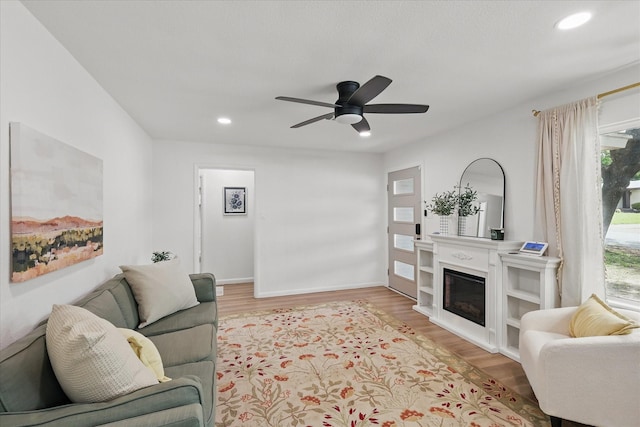 810 Turner Blvd, Grand Prairie, TX 75050 - living room featuring light wood-style flooring, recessed lighting, a ceiling fan, a glass covered fireplace, and baseboards