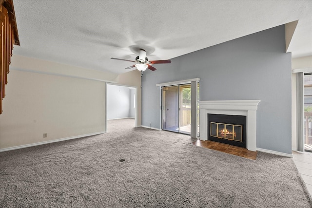 1206 Signal Ridge Pl, Rockwall, TX 75032 - unfurnished living room with a ceiling fan, carpet, a fireplace with flush hearth, a textured ceiling, and baseboards